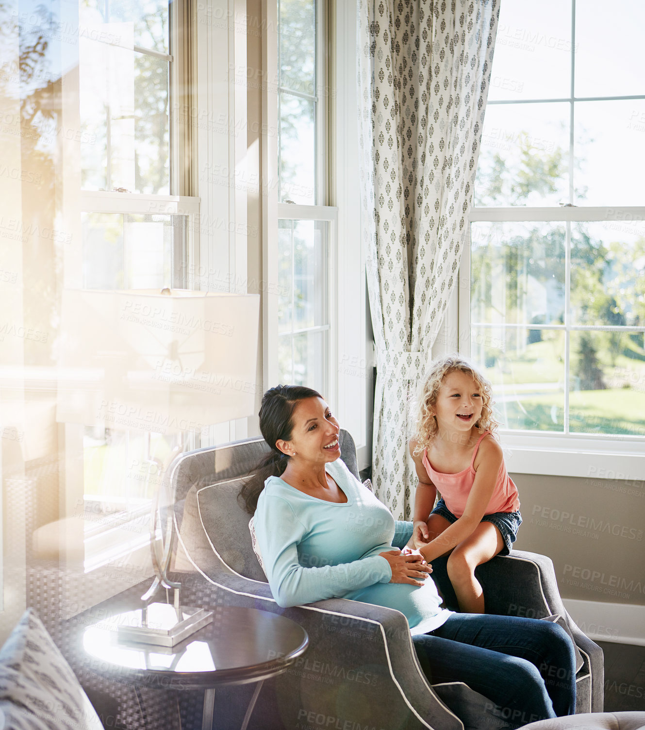 Buy stock photo Shot of a pregnant woman spending time with her daughter at home