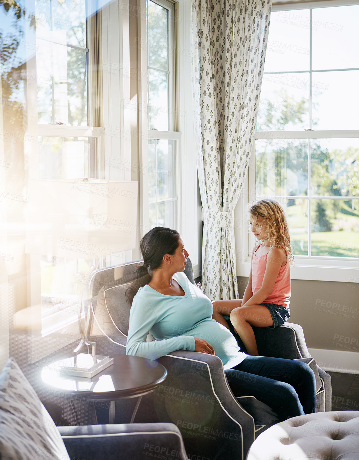 Buy stock photo Shot of a pregnant woman spending time with her daughter at home