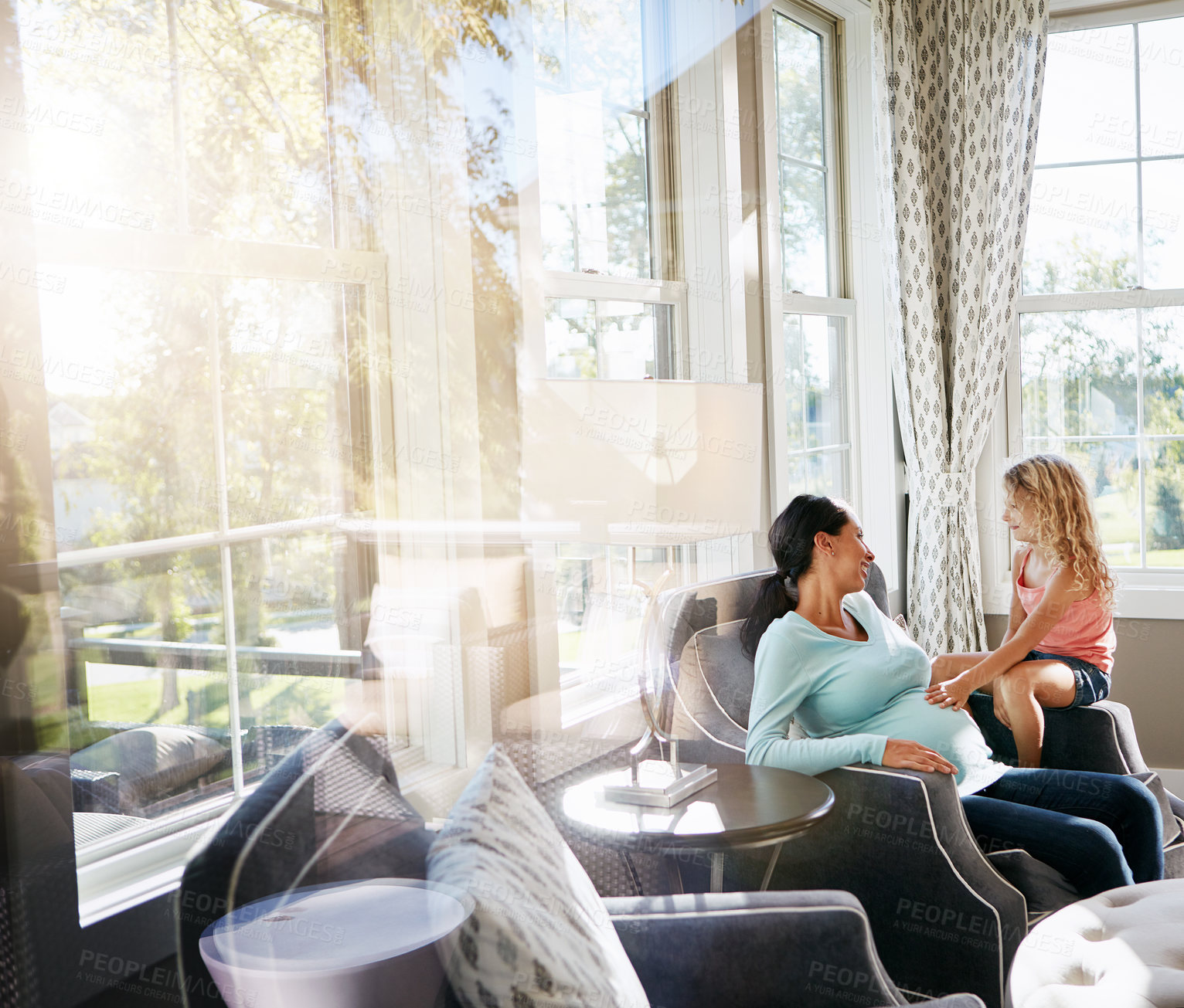 Buy stock photo Shot of a pregnant woman spending time with her daughter at home