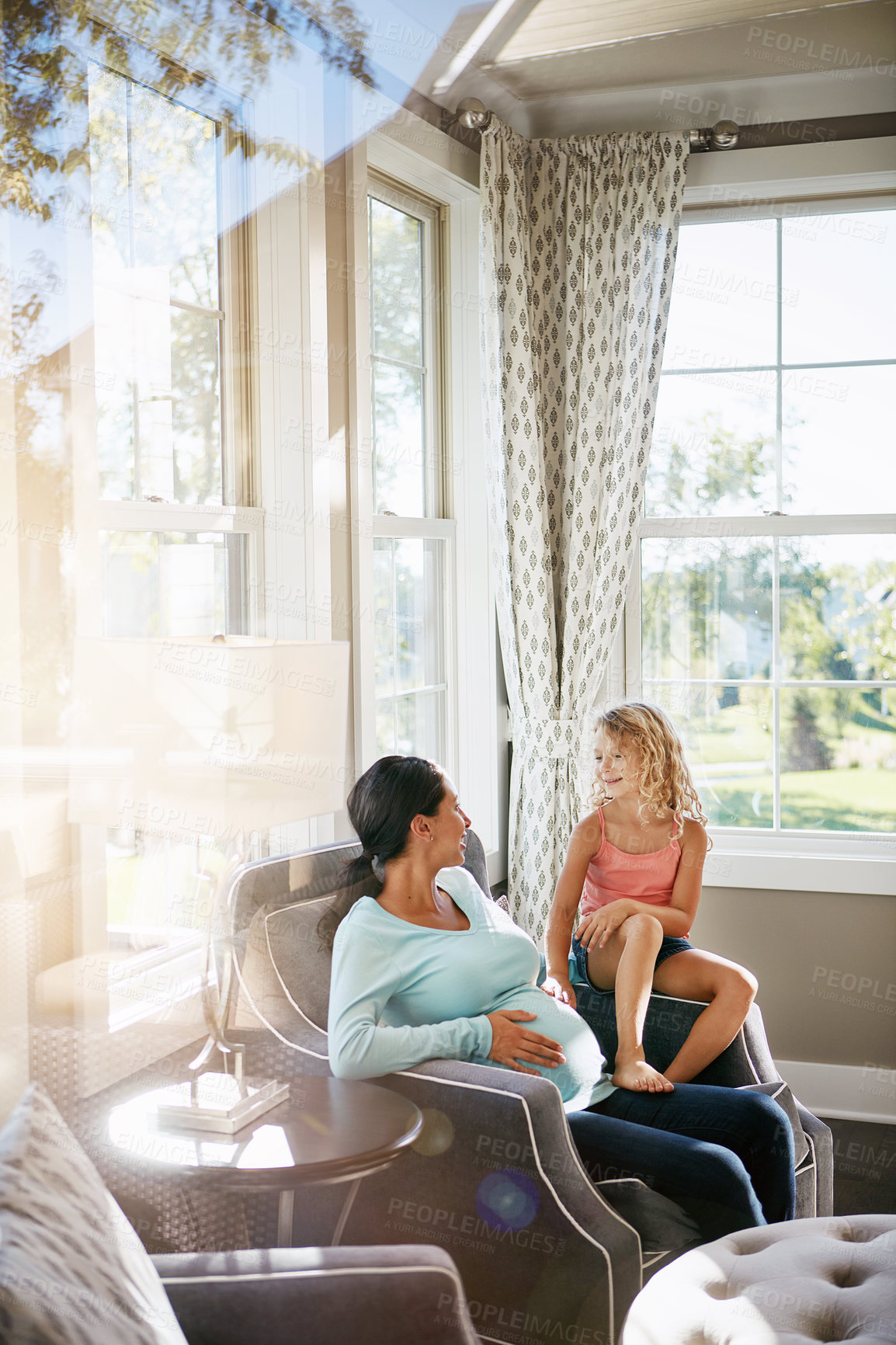 Buy stock photo Belly, pregnant mom and child in home for care, baby growth and bonding together in living room. Pregnancy, girl and mother on sofa with happy kid for love, maternity and touch stomach with flare