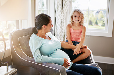 Buy stock photo Shot of a pregnant woman spending time with her daughter at home