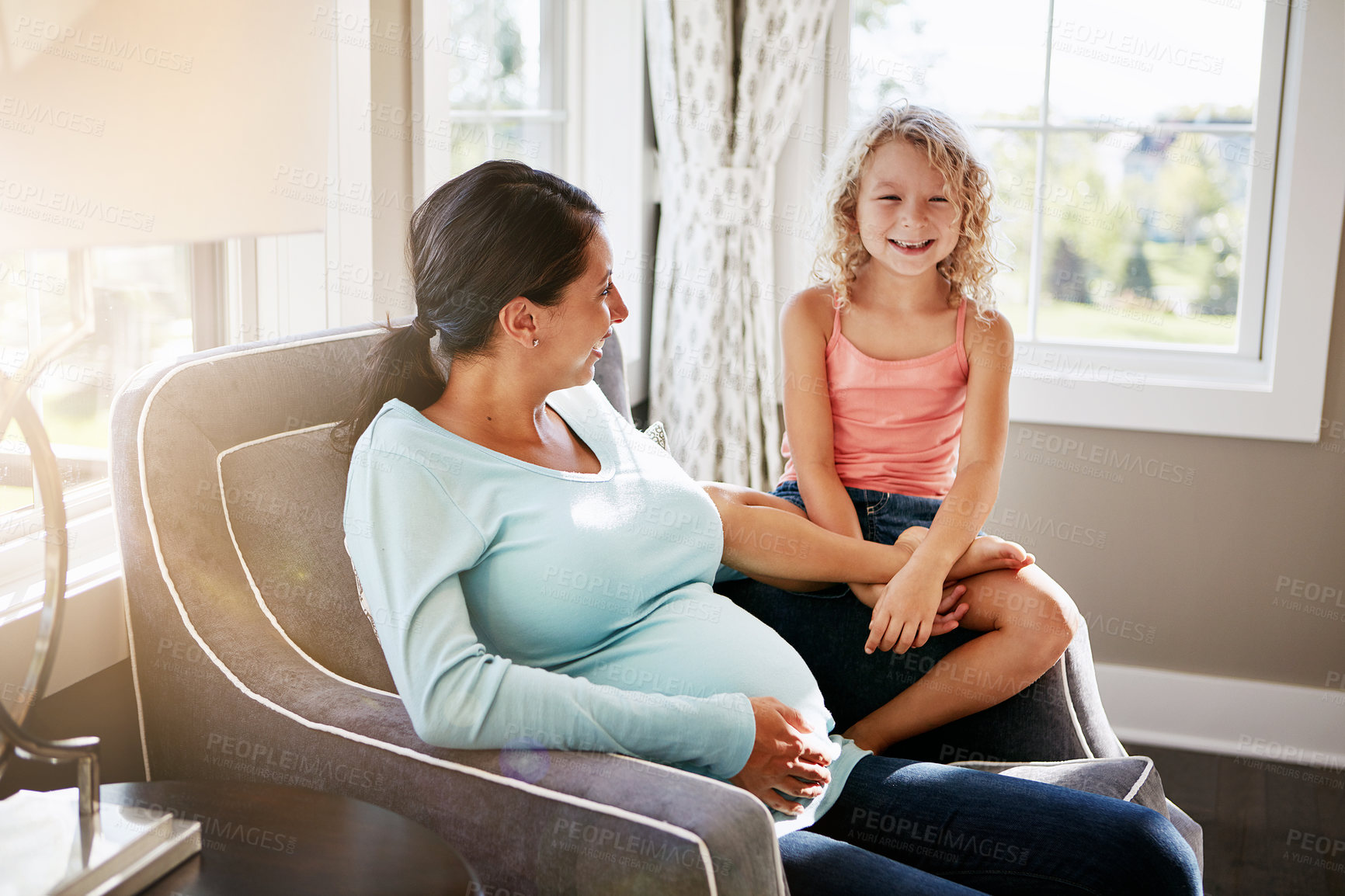 Buy stock photo Shot of a pregnant woman spending time with her daughter at home