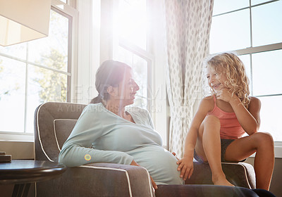 Buy stock photo Shot of a pregnant woman spending time with her daughter at home