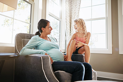 Buy stock photo Shot of a pregnant woman spending time with her daughter at home