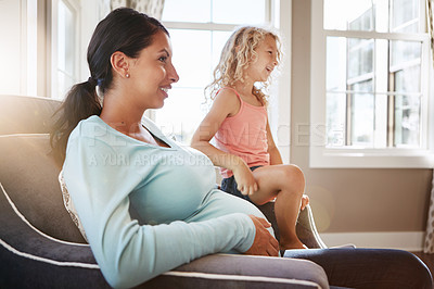 Buy stock photo Shot of a pregnant woman spending time with her daughter at home