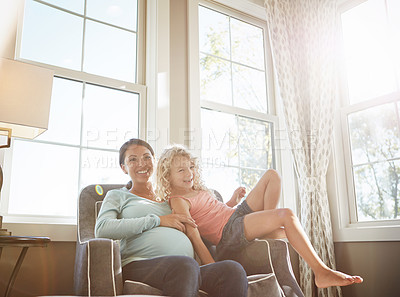 Buy stock photo Shot of a pregnant woman spending time with her daughter at home