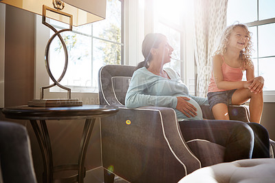 Buy stock photo Shot of a pregnant woman spending time with her daughter at home