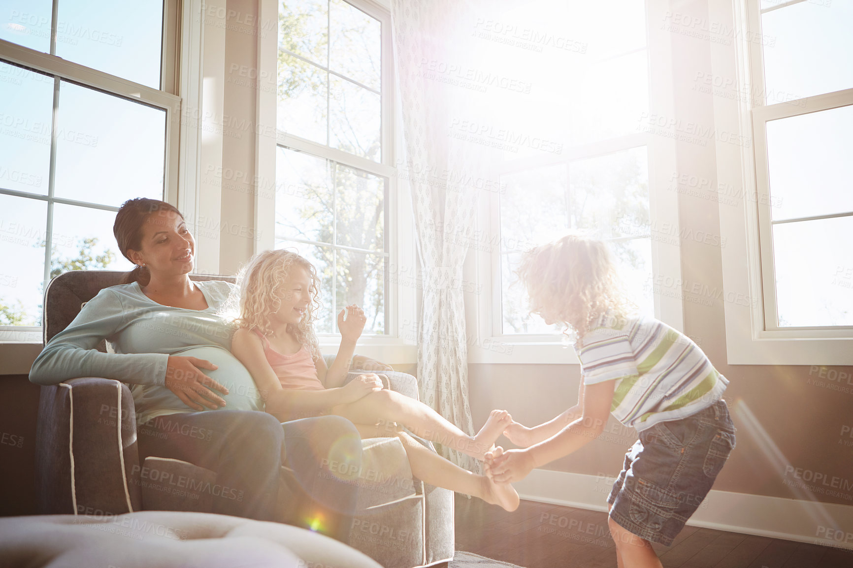 Buy stock photo Shot of a pregnant woman spending time with her children at home