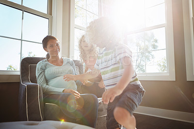 Buy stock photo Shot of a pregnant woman spending time with her children at home