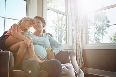 Buy stock photo Shot of a pregnant woman spending time with her daughter at home