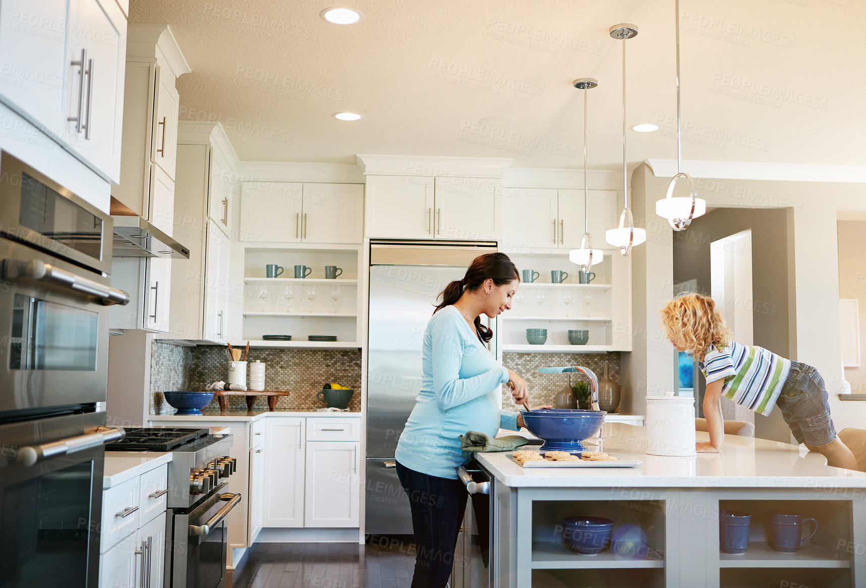 Buy stock photo Mom, kid and pregnant in kitchen with baking in smile for bonding, love and support for child development. Parent, family and happy at home with cookies for fun, enjoy or relax together on lens flare