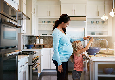 Buy stock photo Mother, daughter and cookies or helping with cooking for learning, bonding and preparation in kitchen with teaching. Family, pregnant woman and girl with baking dessert, cake and sweet snack in house