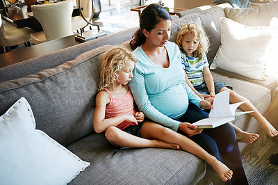 Buy stock photo Shot of a pregnant woman spending time with her children at home