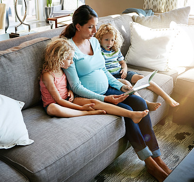 Buy stock photo Shot of a pregnant woman spending time with her children at home