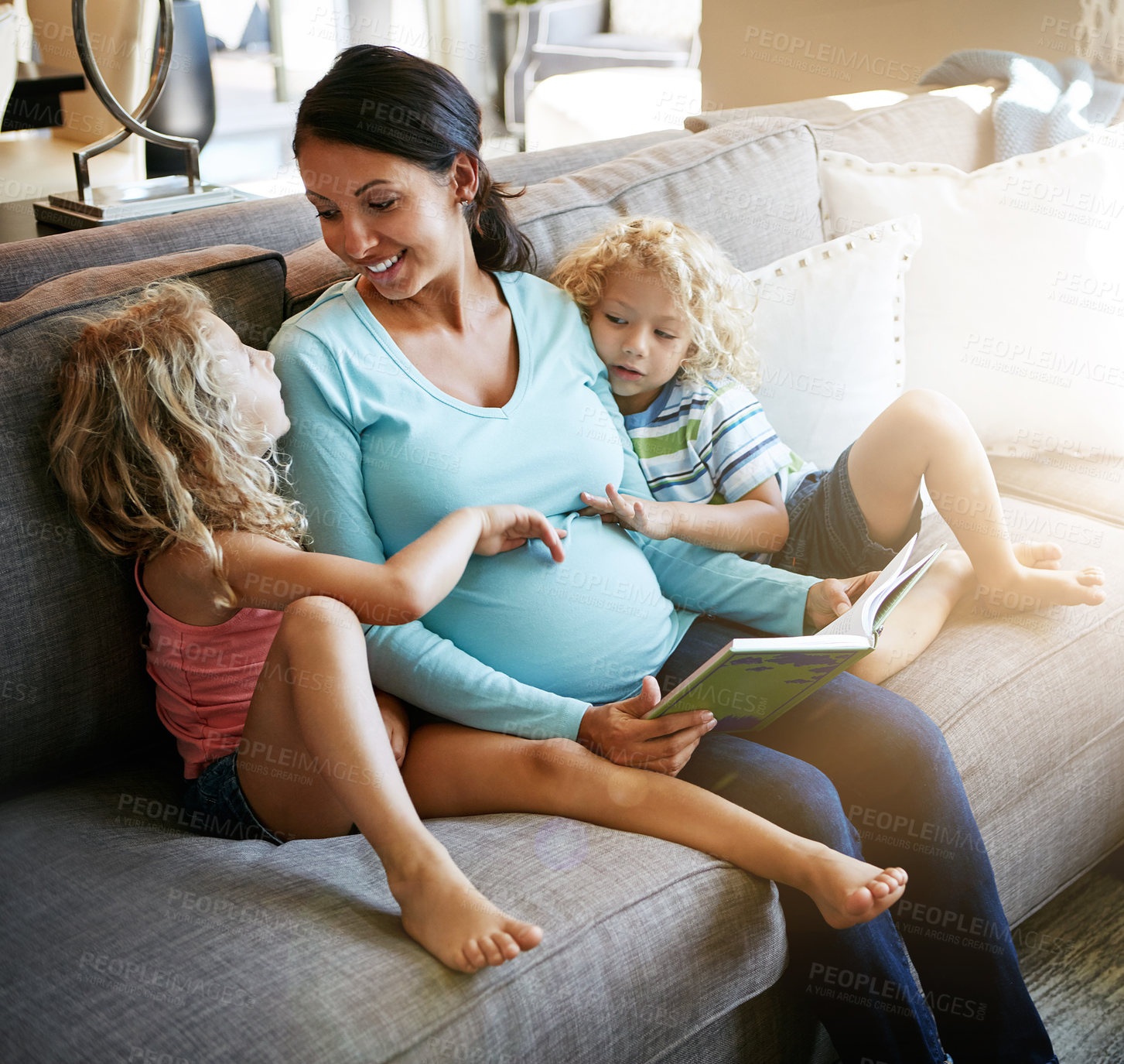 Buy stock photo Shot of a pregnant woman spending time with her children at home