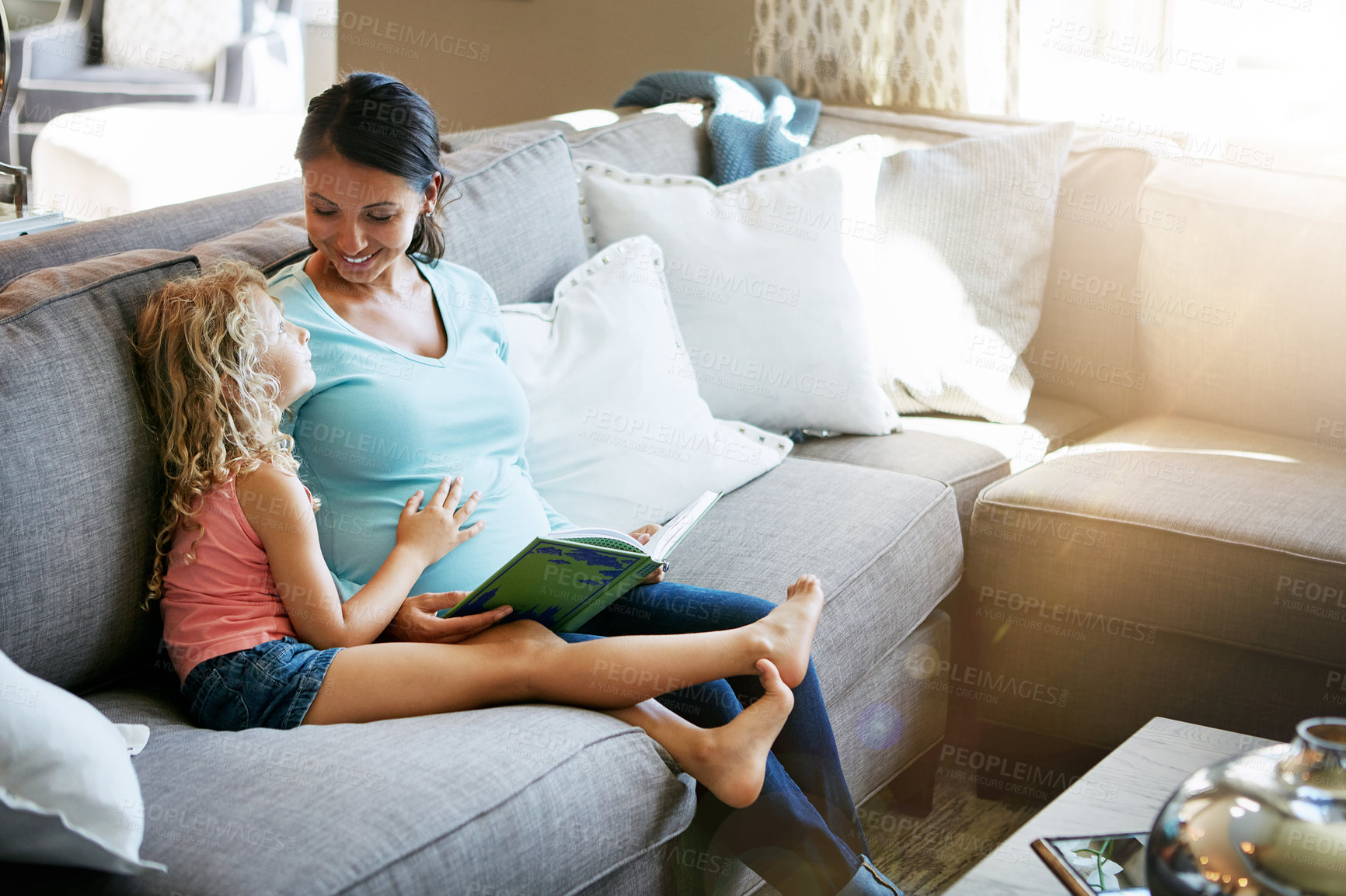 Buy stock photo Shot of a pregnant woman spending time with her daughter at home