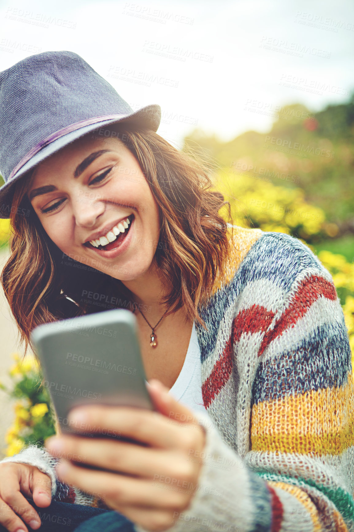 Buy stock photo Shot of an attractive young woman using a mobile phone during a spring day outdoors