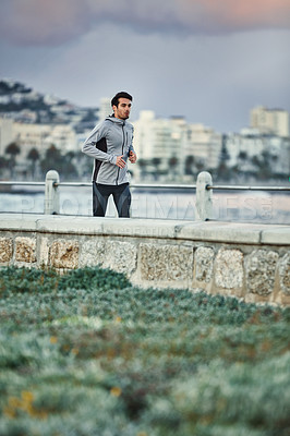 Buy stock photo Shot of a sporty young man out for a run