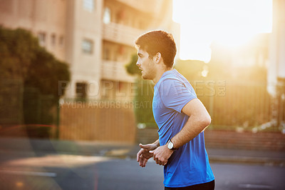 Buy stock photo Shot of a sporty young man out for a run