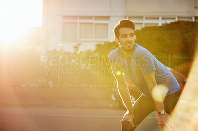 Buy stock photo Shot of a handsome young man exercising outdoors