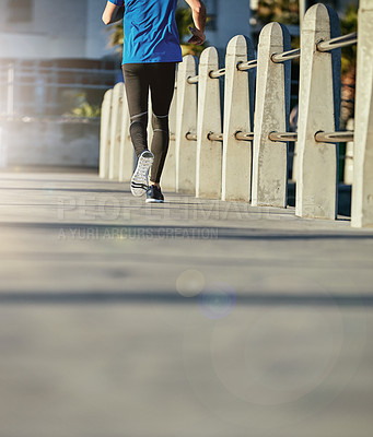 Buy stock photo Rearview shot of a sporty young man out for a run