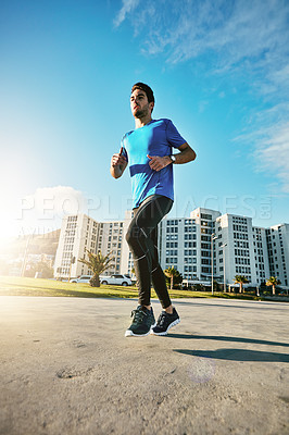 Buy stock photo Shot of a sporty young man out for a run