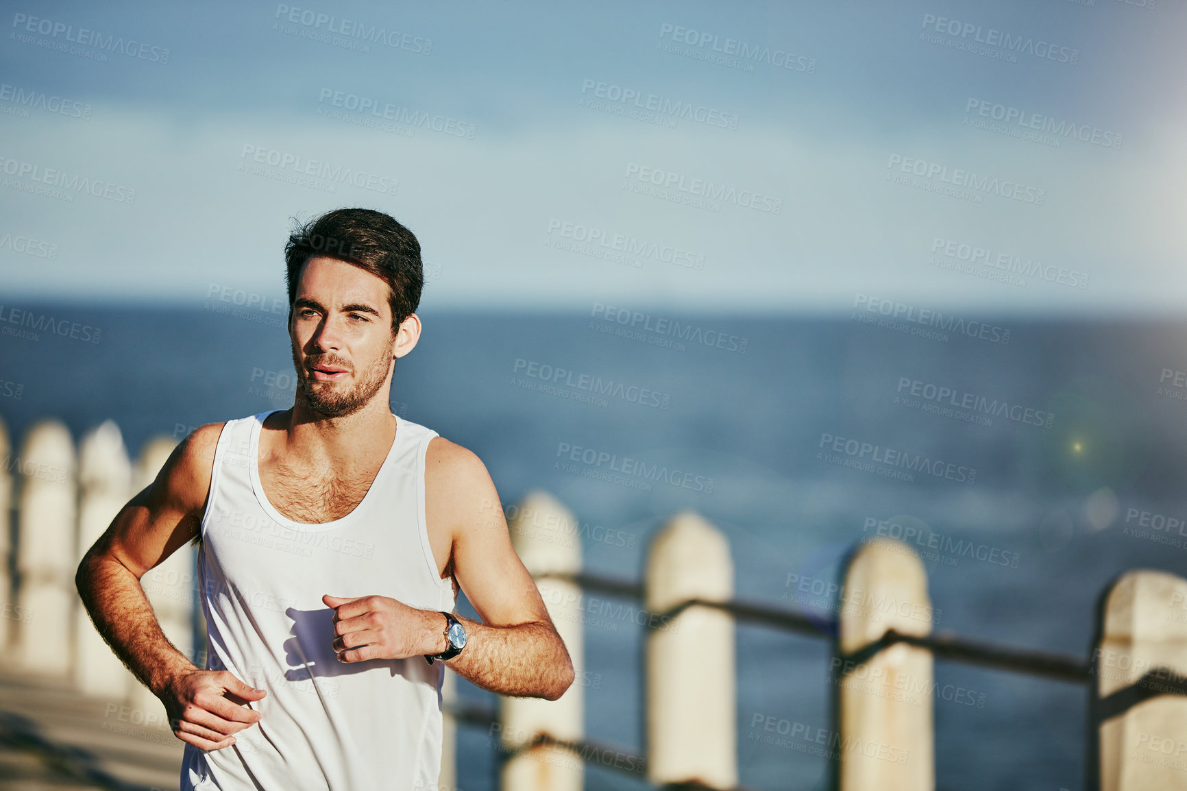 Buy stock photo Shot of a sporty young man out for a run