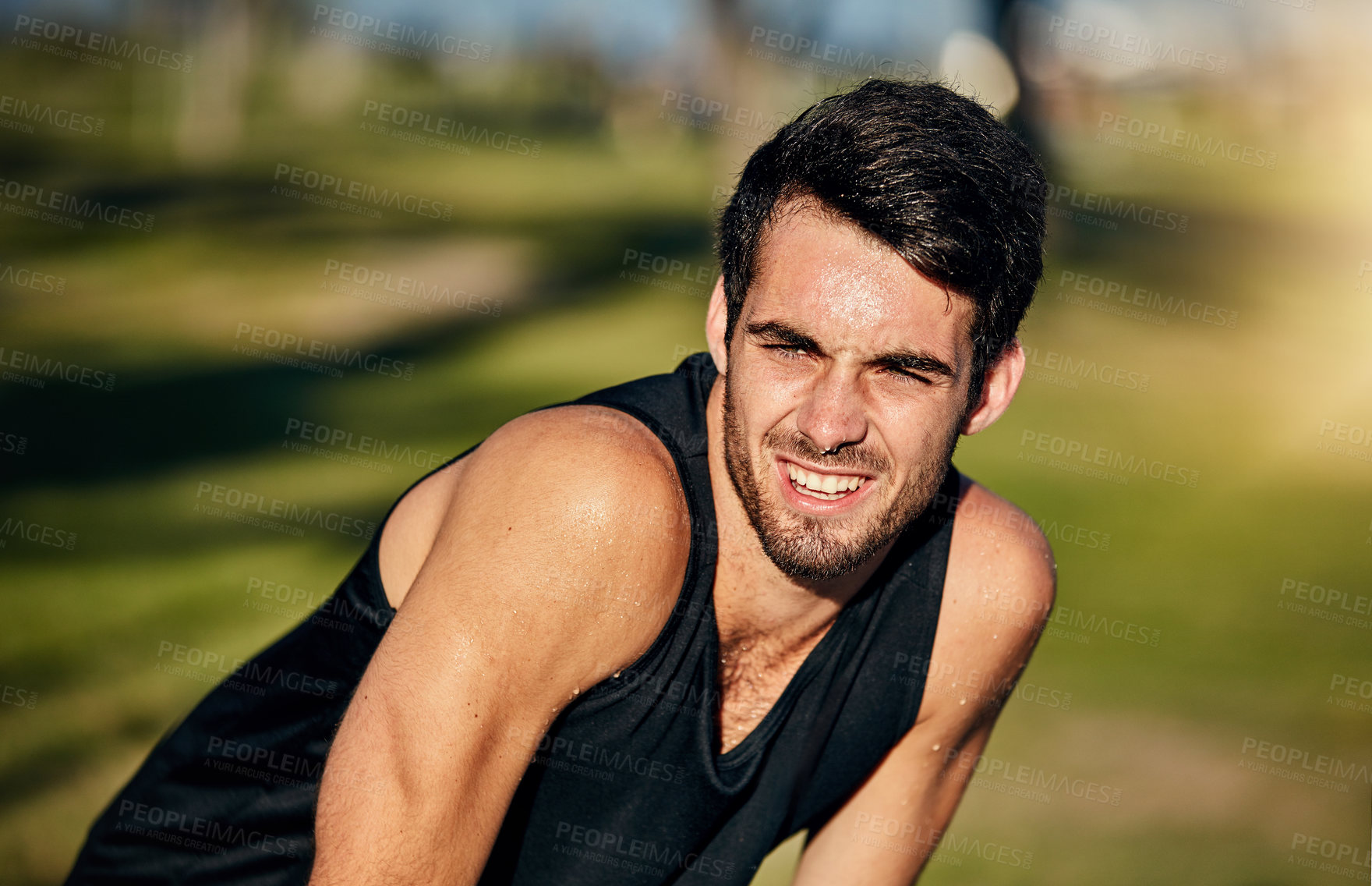 Buy stock photo Shot of a young jogger resting while out for a run in a park