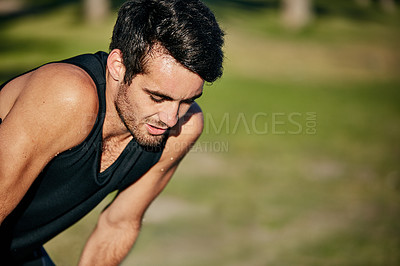 Buy stock photo Shot of a young jogger resting while out for a run in a park