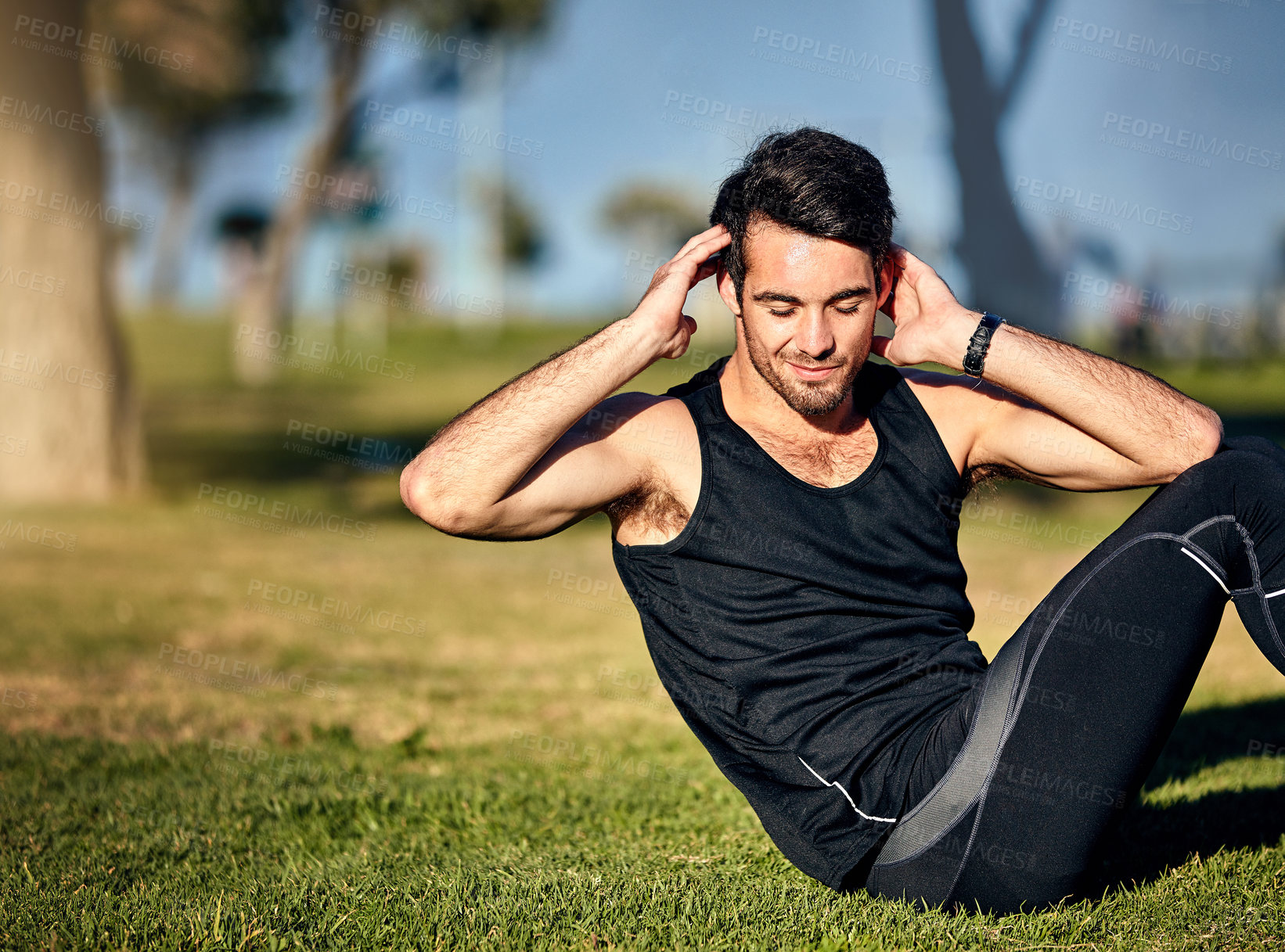 Buy stock photo Shot of a young man in gymwear working out in a park