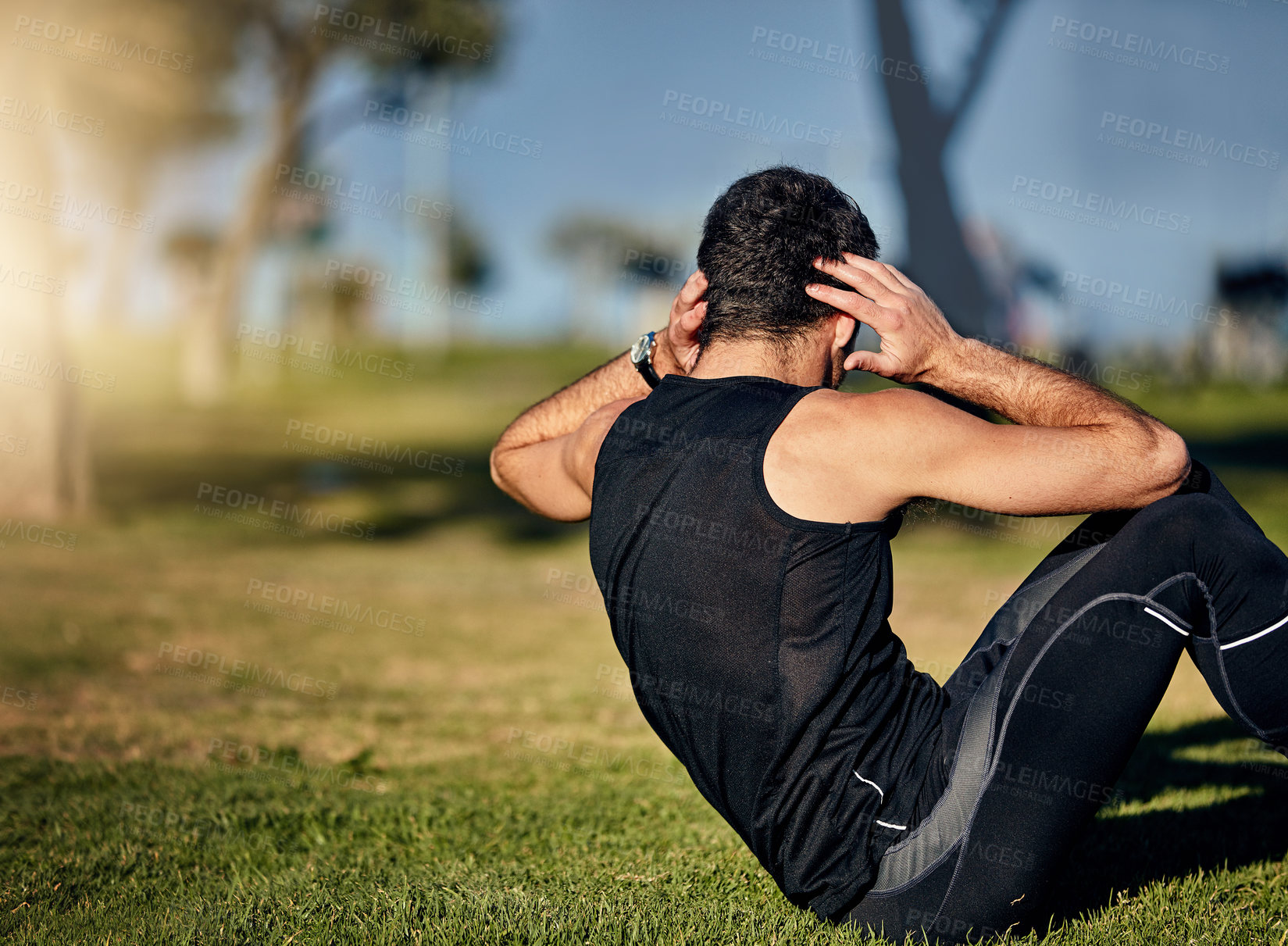 Buy stock photo Shot of a young man in gymwear working out in a park