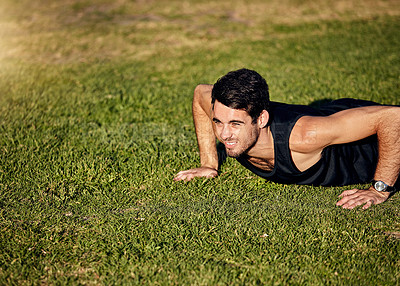 Buy stock photo Shot of a young man in gymwear working out in a park