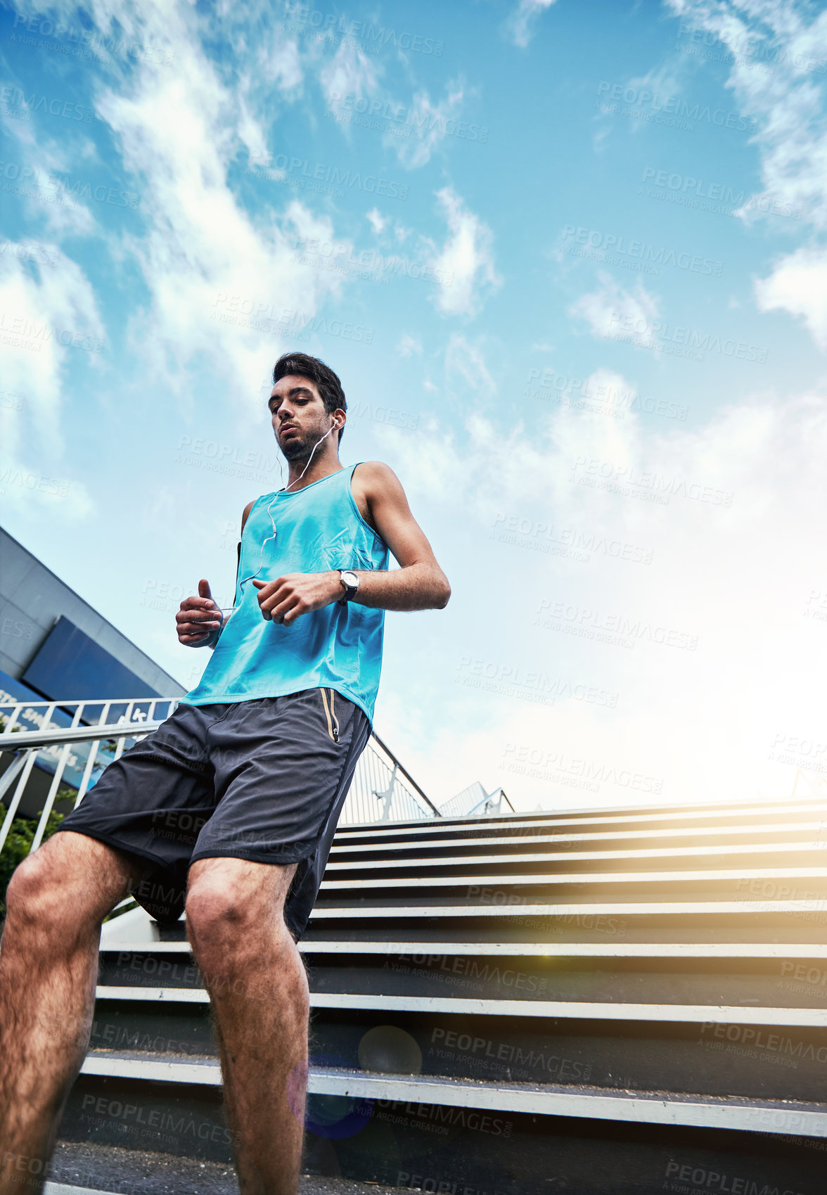 Buy stock photo Low angle shot of a handsome young man working out in the city