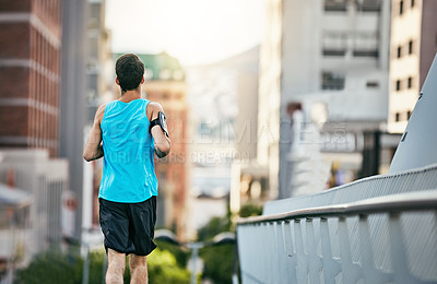 Buy stock photo Rearview shot of a handsome young man working out in the city