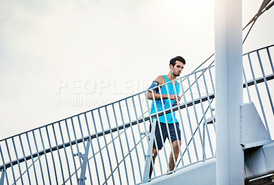 Buy stock photo Low angle shot of a handsome young man working out in the city