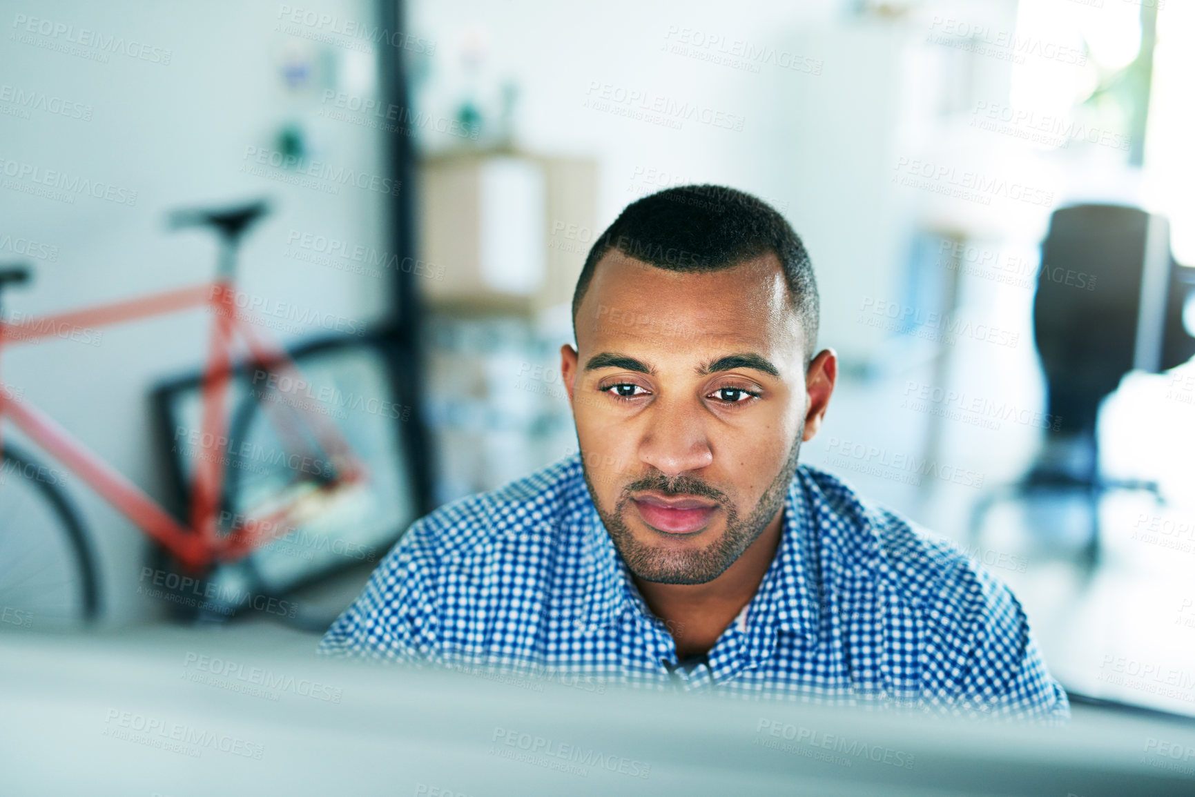 Buy stock photo Cropped shot of a handsome young businessman working in his office