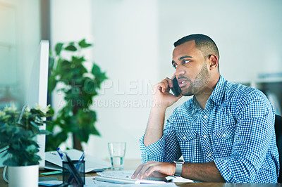 Buy stock photo Shot of a handsome young businessman making a phonecall while working in his office