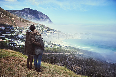 Buy stock photo Rearview shot of an affectionate young couple enjoying a hike in the mountains