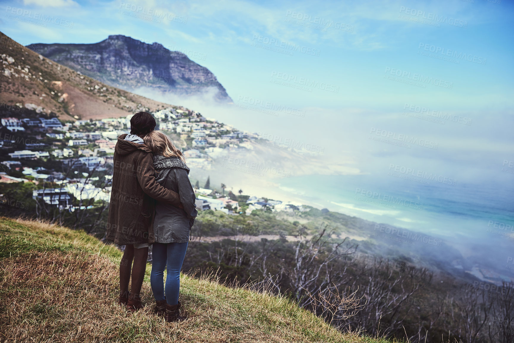 Buy stock photo Rearview shot of an affectionate young couple enjoying a hike in the mountains