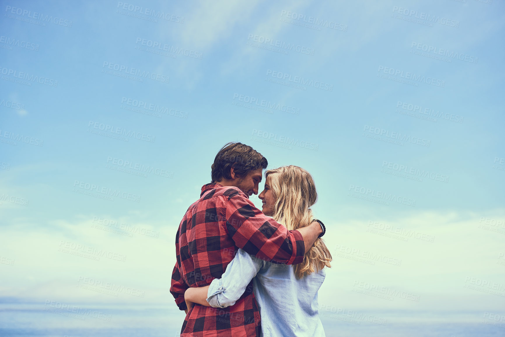 Buy stock photo Shot of an affectionate young couple enjoying a hike in the mountains