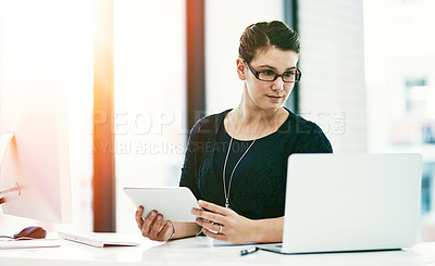 Buy stock photo Shot of a young businesswoman working at her desk in an office