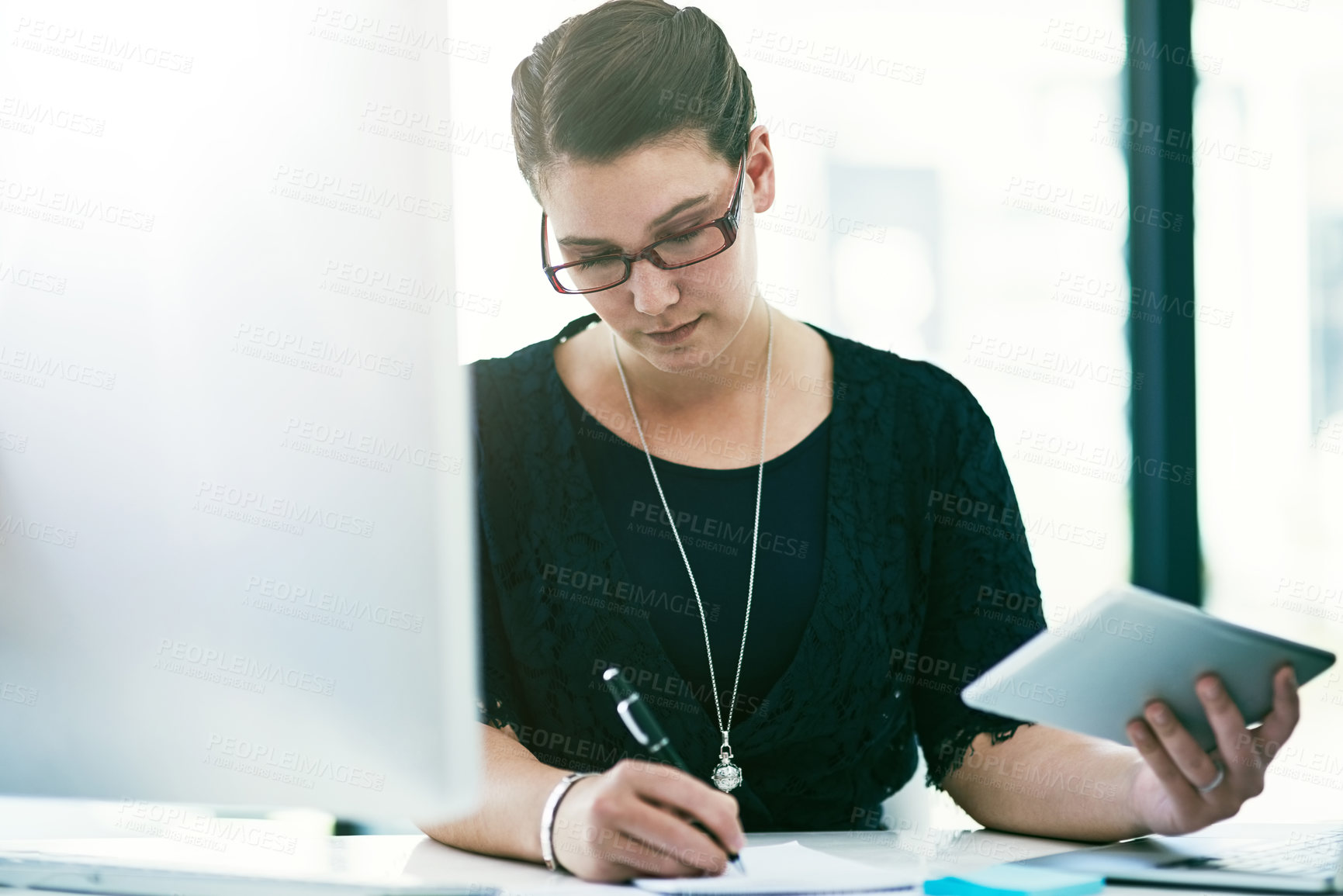 Buy stock photo Shot of a young businesswoman working at her desk in an office