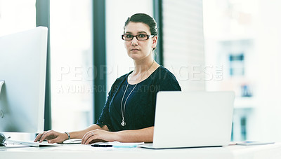 Buy stock photo Portrait of a young businesswoman working at her desk in an office