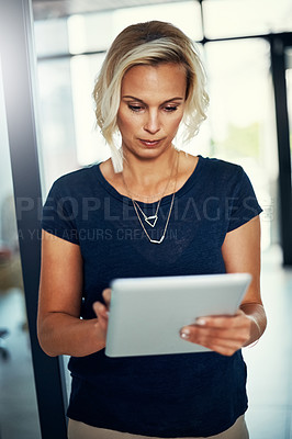 Buy stock photo Cropped shot of a young businesswoman using a digital tablet in an office