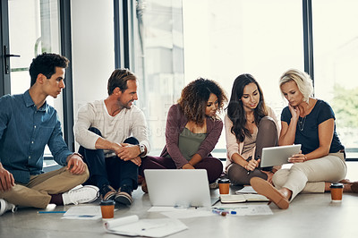 Buy stock photo Shot of a group of designers brainstorming on the floor in an office