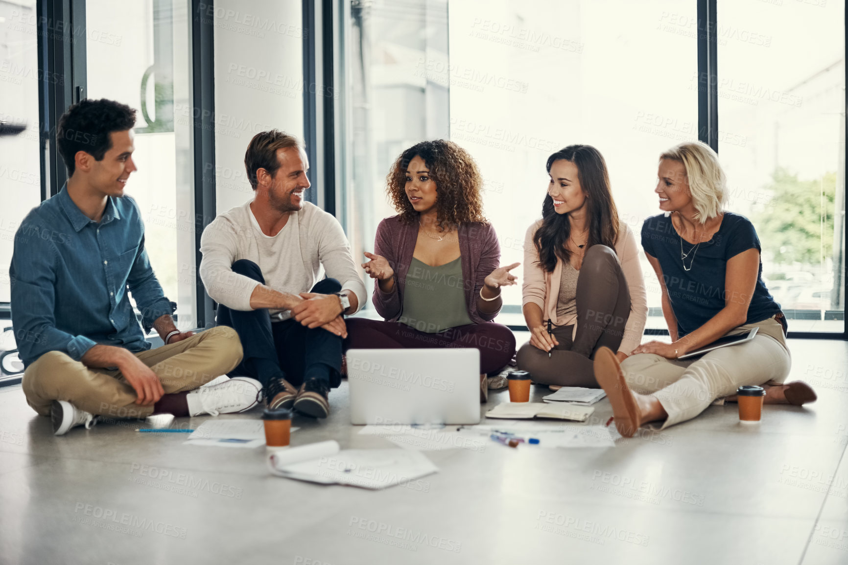 Buy stock photo Shot of a group of designers brainstorming on the floor in an office