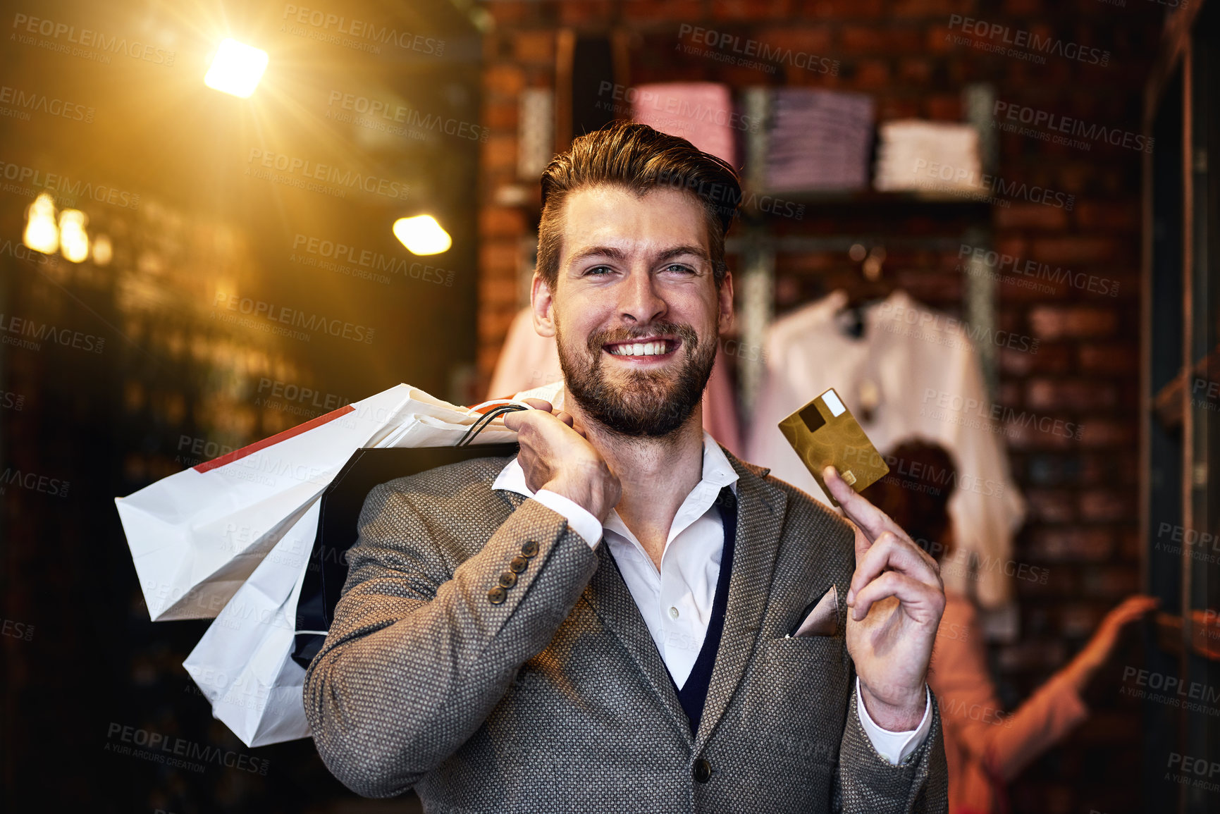 Buy stock photo Shot of a man holding up his credit card while out shopping