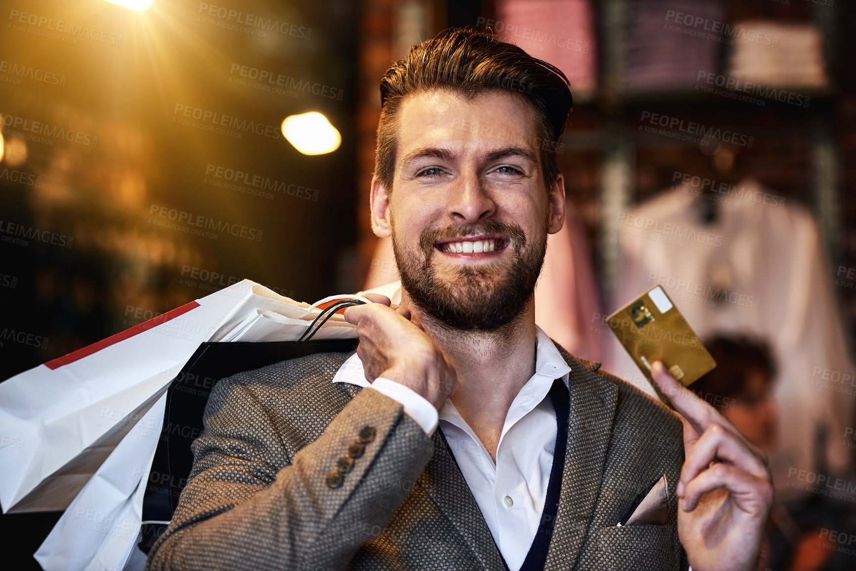 Buy stock photo Shot of a man holding up his credit card while out shopping
