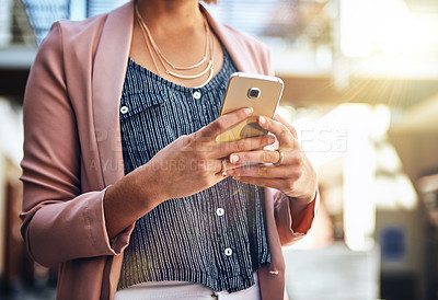 Buy stock photo Cropped shot of a young woman using her cellphone
