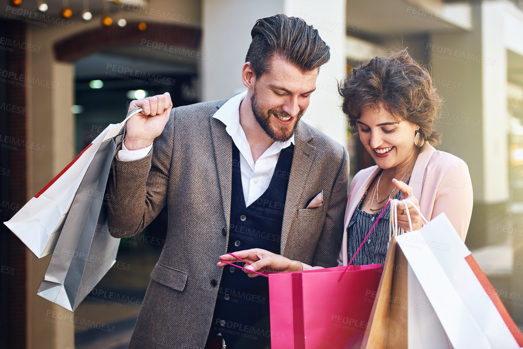 Buy stock photo Shot of a woman showing her boyfriend what she bought while out shopping